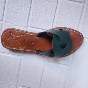 leather sandals women, Moroccan green sandals, handmade summer slides, women’s boho sandals, flat leather slippers, forest green leather, artisanal Moroccan footwear, beach sandals women, vacation sandals, open toe leather flats, brown sole sandals, soft leather shoes, Moroccan artisan slides, barefoot minimalist shoes, green leather sandals, summer flat shoes, natural leather flats, handmade casual sandals, slip-on sandals leather, handcrafted women shoes, Moroccan twist strap sandals