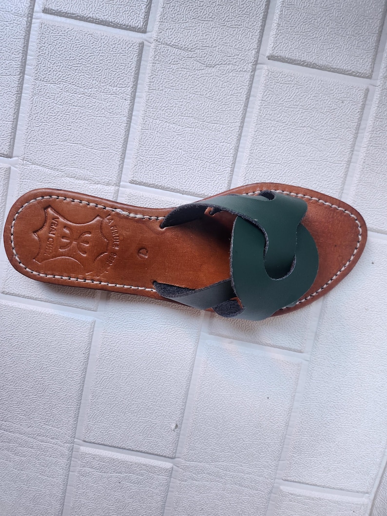 leather sandals women, Moroccan green sandals, handmade summer slides, women’s boho sandals, flat leather slippers, forest green leather, artisanal Moroccan footwear, beach sandals women, vacation sandals, open toe leather flats, brown sole sandals, soft leather shoes, Moroccan artisan slides, barefoot minimalist shoes, green leather sandals, summer flat shoes, natural leather flats, handmade casual sandals, slip-on sandals leather, handcrafted women shoes, Moroccan twist strap sandals