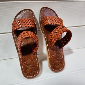woven leather sandals, moroccan leather sandals, boho sandals women, brown leather sandals, braided leather sandals, artisan flat shoes, moroccan slides, handmade slippers women, summer beach sandals, bohemian leather sandals, real leather sandals, flat moroccan sandals, comfy summer shoes, leather sandals for women, vacation sandals, moroccan fashion shoes, traditional moroccan slippers, stylish flat sandals, rustic leather shoes, braided slide sandals, slip on boho sandals, boho flat leather