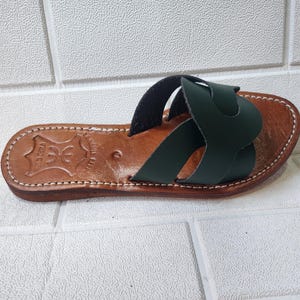 leather sandals women, Moroccan green sandals, handmade summer slides, women’s boho sandals, flat leather slippers, forest green leather, artisanal Moroccan footwear, beach sandals women, vacation sandals, open toe leather flats, brown sole sandals, soft leather shoes, Moroccan artisan slides, barefoot minimalist shoes, green leather sandals, summer flat shoes, natural leather flats, handmade casual sandals, slip-on sandals leather, handcrafted women shoes, Moroccan twist strap sandals
