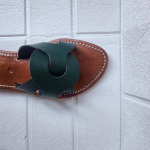 leather sandals women, Moroccan green sandals, handmade summer slides, women’s boho sandals, flat leather slippers, forest green leather, artisanal Moroccan footwear, beach sandals women, vacation sandals, open toe leather flats, brown sole sandals, soft leather shoes, Moroccan artisan slides, barefoot minimalist shoes, green leather sandals, summer flat shoes, natural leather flats, handmade casual sandals, slip-on sandals leather, handcrafted women shoes, Moroccan twist strap sandals