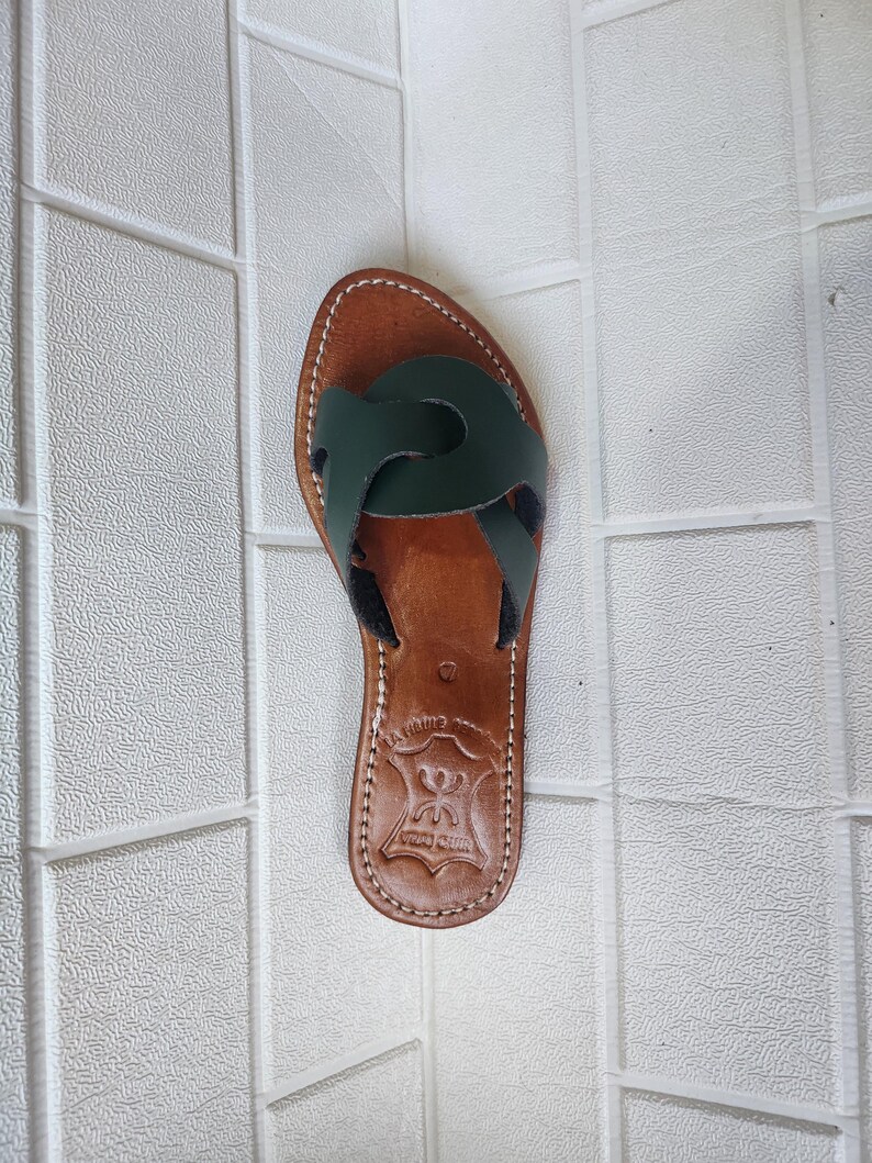 leather sandals women, Moroccan green sandals, handmade summer slides, women’s boho sandals, flat leather slippers, forest green leather, artisanal Moroccan footwear, beach sandals women, vacation sandals, open toe leather flats, brown sole sandals, soft leather shoes, Moroccan artisan slides, barefoot minimalist shoes, green leather sandals, summer flat shoes, natural leather flats, handmade casual sandals, slip-on sandals leather, handcrafted women shoes, Moroccan twist strap sandals