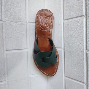 leather sandals women, Moroccan green sandals, handmade summer slides, women’s boho sandals, flat leather slippers, forest green leather, artisanal Moroccan footwear, beach sandals women, vacation sandals, open toe leather flats, brown sole sandals, soft leather shoes, Moroccan artisan slides, barefoot minimalist shoes, green leather sandals, summer flat shoes, natural leather flats, handmade casual sandals, slip-on sandals leather, handcrafted women shoes, Moroccan twist strap sandals