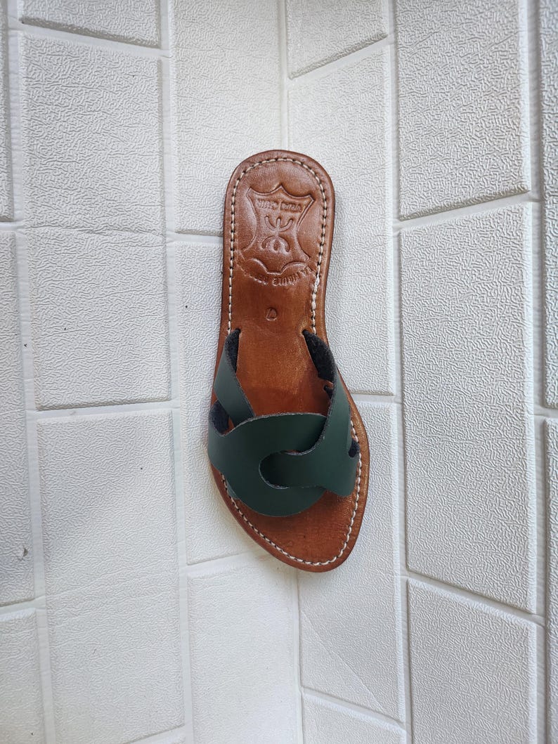 leather sandals women, Moroccan green sandals, handmade summer slides, women’s boho sandals, flat leather slippers, forest green leather, artisanal Moroccan footwear, beach sandals women, vacation sandals, open toe leather flats, brown sole sandals, soft leather shoes, Moroccan artisan slides, barefoot minimalist shoes, green leather sandals, summer flat shoes, natural leather flats, handmade casual sandals, slip-on sandals leather, handcrafted women shoes, Moroccan twist strap sandals