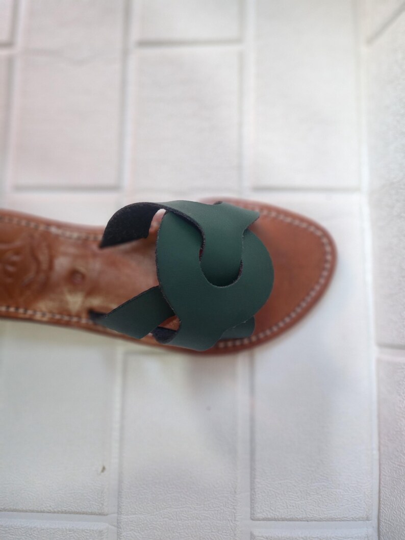 leather sandals women, Moroccan green sandals, handmade summer slides, women’s boho sandals, flat leather slippers, forest green leather, artisanal Moroccan footwear, beach sandals women, vacation sandals, open toe leather flats, brown sole sandals, soft leather shoes, Moroccan artisan slides, barefoot minimalist shoes, green leather sandals, summer flat shoes, natural leather flats, handmade casual sandals, slip-on sandals leather, handcrafted women shoes, Moroccan twist strap sandals