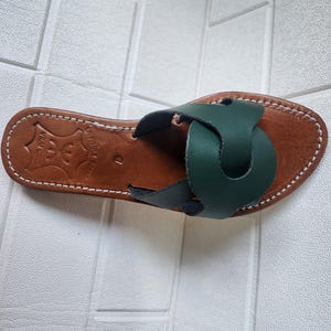 leather sandals women, Moroccan green sandals, handmade summer slides, women’s boho sandals, flat leather slippers, forest green leather, artisanal Moroccan footwear, beach sandals women, vacation sandals, open toe leather flats, brown sole sandals, soft leather shoes, Moroccan artisan slides, barefoot minimalist shoes, green leather sandals, summer flat shoes, natural leather flats, handmade casual sandals, slip-on sandals leather, handcrafted women shoes, Moroccan twist strap sandals