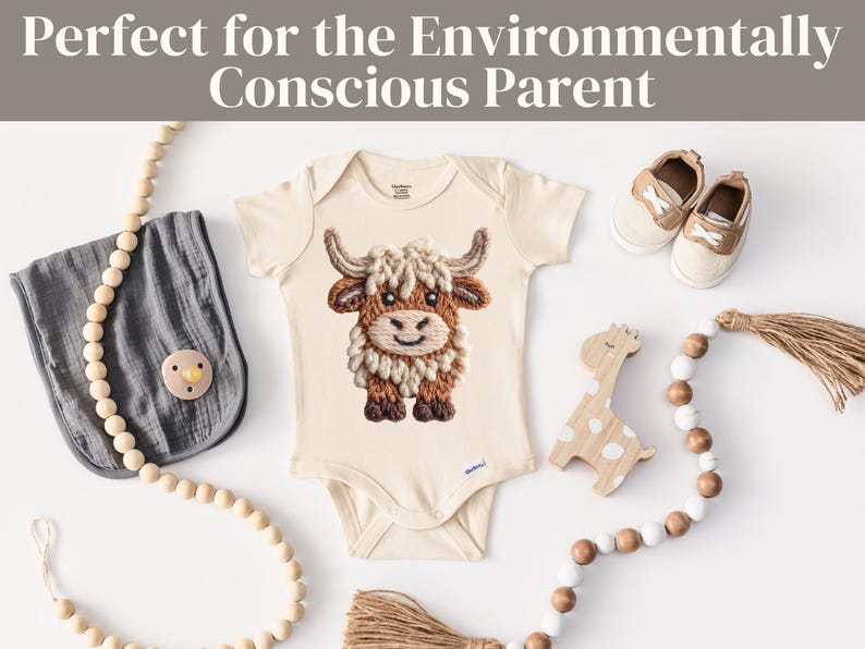 Pode incluir: Body de beb&eacute; creme com um design bordado de vaca Highland. A imagem inclui um babete cinzento, uma girafa de madeira, uma chupeta, sapatos e uma grinalda de contas de madeira. O texto na parte superior diz "Perfect for the Environmentally Conscious Parent."