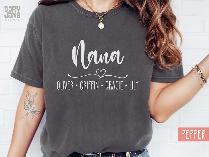 May include: A dark gray t-shirt with the word "Nana" in white text and a heart design. Below the word "Nana" are the names "Oliver, Griffin, Gracie, Lily" in white text.