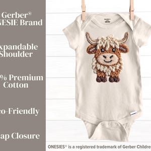 Pode incluir: Body de beb&eacute; creme com um design bordado de vaca das Terras Altas. O body tem um ombro expans&iacute;vel e fecho de press&atilde;o. O texto na lateral diz "Gerber ONESIE Brand", "Expandable Shoulder", "100% Premium Cotton", "Eco-Friendly" e "Snap Closure".