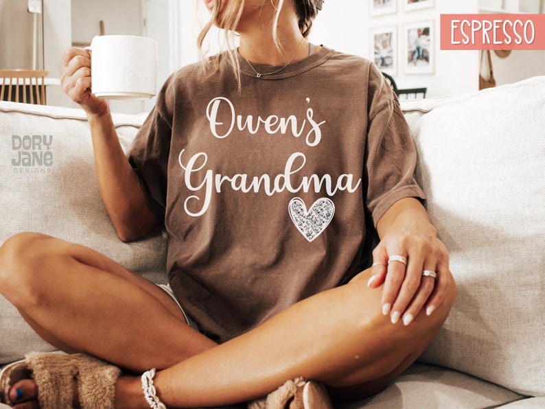 May include: A brown t-shirt with the text "Owen's Grandma" in white lettering and a sparkly silver heart.