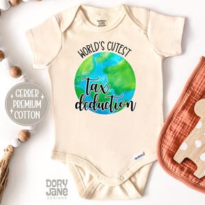 May include: A beige baby onesie with a watercolor illustration of the Earth and the text "World's Cutest Tax Deduction".
