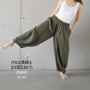 Puede incluir: Pantalones harén verde oliva con cintura fruncida y bolsillos. Los pantalones se combinan con una camiseta sin mangas blanca. El texto "modella pattern PIRAYE XS-XXL" es visible.