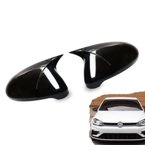 Könnte beinhalten: Zwei glänzend schwarze Seitenspiegelkappen mit spitzem, aerodynamischem Design, abgebildet neben einem weißen Volkswagen Golf Schrägheck, der denselben Stil schwarzer Seitenspiegelkappen an seinem Außenrahmen montiert hat.