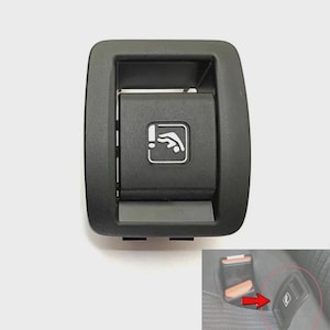 Op de afbeelding: Een zwarte, rechthoekige ontgrendelingsknop voor autostoelen met een wit icoon van een kantelbare rugleuning. De knop heeft een gladde, matte afwerking en een verzonken middengedeelte. Een kleine afbeelding toont de knop in een autostoel.