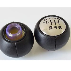 May include: Black leather gear shift knob with a silver top. The top has the numbers 1, 3, 5, R, and 2, 4, 6 printed on it.