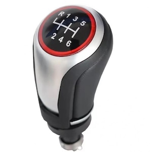 May include: A black leather gear shift knob with a silver base and a red ring around the top. The top of the knob has a black and white gear shift pattern with the numbers 1, 2, 3, 4, 5, 6, and R.
