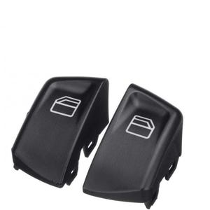 May include: Two black plastic car window switch buttons with a rectangular outline graphic on each button.