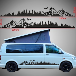Könnte beinhalten: Schwarzes Berg- und Wald-Vinyl-Aufkleber-Set. Die Aufkleber sind 200 cm lang und 25 cm hoch. Das Bild zeigt die Aufkleber auf einem weißen Van. Die Aufkleber zeigen eine Bergkette, Bäume und Vögel.