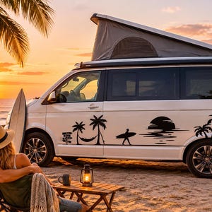May include: A white camper van featuring black vinyl decals of palm trees, a hammock, a surfer carrying a board, and a sunset. The van has a pop-up roof and is parked on a sandy beach during a golden sunset with a surfboard leaning against it.