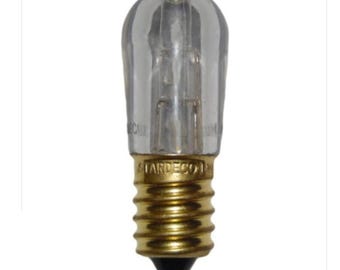 May include: A clear, elongated light bulb with a gold-colored screw base. The bulb has a rounded top and visible internal filaments. The base is marked with the text "STARDECO".