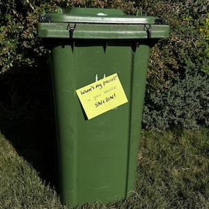 Puede incluir: Un contenedor de reciclaje verde con una nota adhesiva amarilla pegada. La nota dice "Where's my parcel? in your wheelie SACEBIN!"