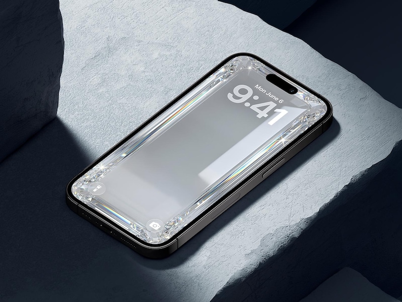 May include: A black smartphone with a clear, bejeweled screen protector. The screen displays the time, 9:41, and the date, Monday, June 6. The phone is set against a textured, light gray surface with dark shadows.