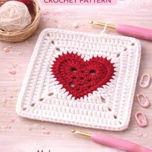 May include: A crocheted heart square with a red heart in the centre, surrounded by a white border. The image includes crochet hooks, yarn, and the text "Heart Square Crochet Pattern". The text "Make your own sweet granny squares!" is also visible.