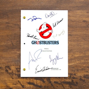 Pode incluir: Uma página de roteiro branca para o filme "Ghostbusters" com o logotipo dos Ghostbusters e as assinaturas do elenco e da equipe, incluindo Bill Murray, Dan Aykroyd, Harold Ramis, Ernie Hudson e Sigourney Weaver.