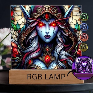 May include: An RGB lamp featuring a fantasy character with red eyes and intricate details. The lamp has a wooden base and displays the text "RGB LAMP". The image has a stained-glass style with a variety of colors.