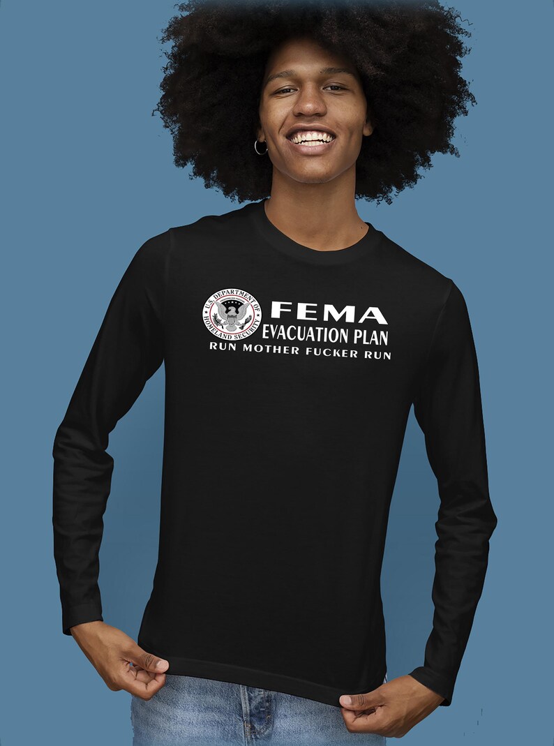 A person with voluminous dark hair wearing a black long-sleeve shirt displaying the FEMA evacuation plan design.