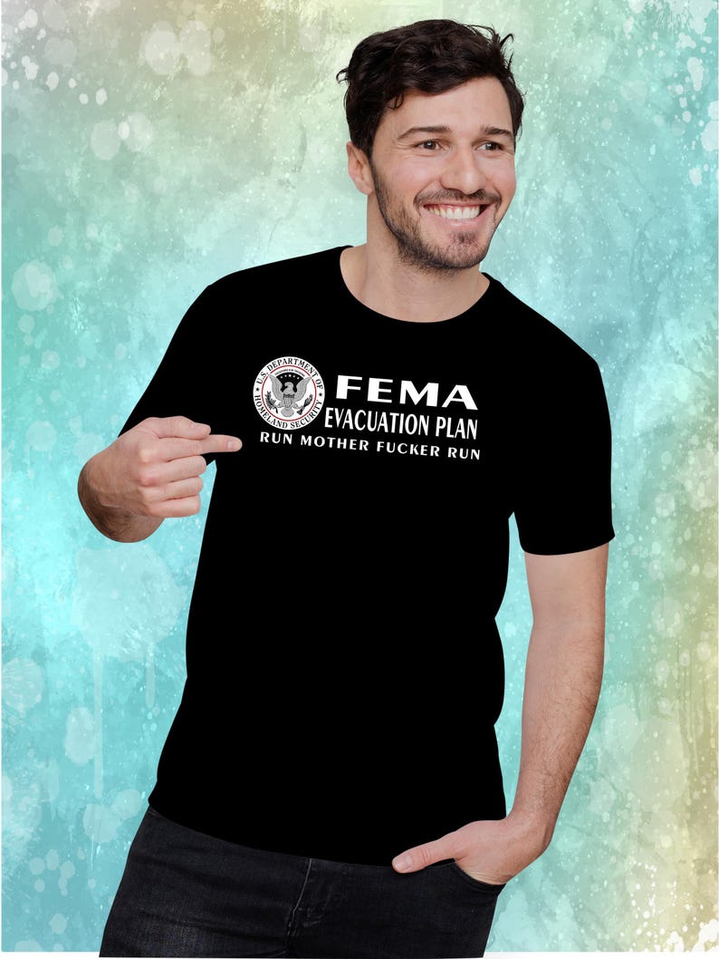 A man pointing at a black t-shirt printed with the FEMA evacuation plan graphic and text.
