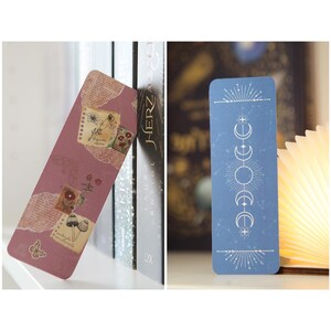 May include: Two bookmarks, one with a pink background and floral designs, and the other with a blue background and a white moon and star design.