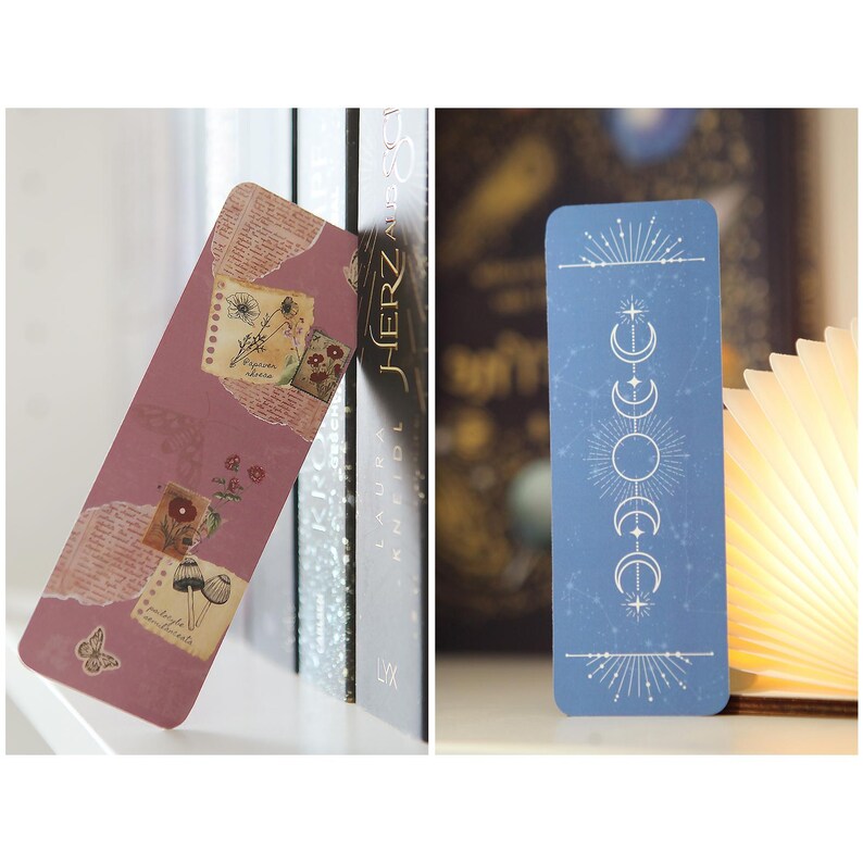 May include: Two bookmarks, one with a pink background and floral designs, and the other with a blue background and a white moon and star design.