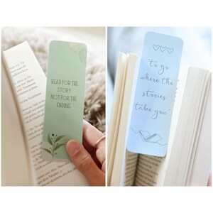 May include: Two bookmarks with inspirational quotes about reading. The first bookmark is green with a leafy design and the text "Read for the story. Not for the ending." The second bookmark is light blue with a simple drawing of a book and the text "To go where the stories take you."