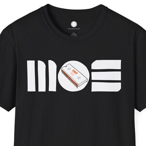 May include: Black t-shirt with the word "MOS" in white block letters. The "O" is a circle containing a small illustration of a circuit board. The shirt is short-sleeved and made of a soft material.