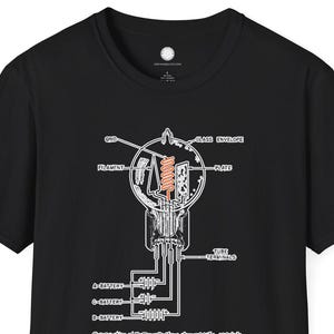 Puede incluir: Camiseta negra con un diagrama detallado de un tubo de vacío en blanco y naranja. El diagrama incluye etiquetas como "filamento", "placa" y "envolvente de vidrio". El diseño muestra los componentes internos y el cableado del tubo.