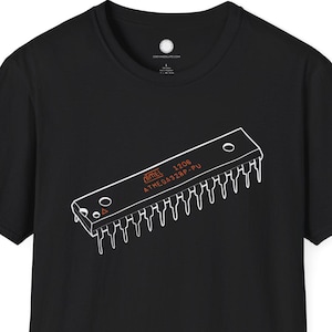 Pode incluir: Camiseta preta com um desenho de linha branca de um chip de computador. O design do chip inclui o texto "ATMEL 1206 ATMEGA328P-PU". A camiseta é de gola redonda e manga curta.