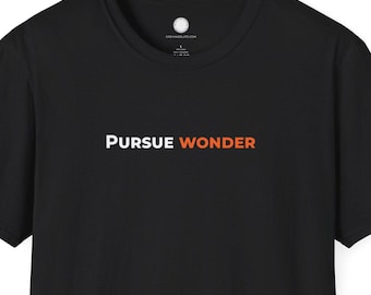 May include: Black t-shirt with the words "PURSUE WONDER" printed across the chest in white and orange. The shirt has short sleeves and a crew neck. The fabric appears to be a soft cotton blend.