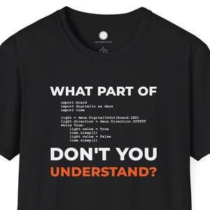 Może przedstawiać: Czarna koszulka z białym tekstem "WHAT PART OF" a następnie kodem i "DON'T YOU UNDERSTAND?" w kolorze pomarańczowym. Koszulka ma okrągły dekolt i krótkie rękawy.