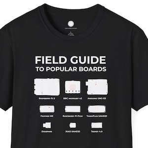 May include: Black t-shirt featuring the white text "FIELD GUIDE TO POPULAR BOARDS". The shirt displays illustrations of popular electronic boards, such as Raspberry Pi and Arduino. A casual garment for tech enthusiasts.