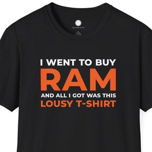 以下が含まれることがあります： 「I WENT TO BUY RAM AND ALL I GOT WAS THIS LOUSY T-SHIRT」の文字が白とオレンジでプリントされた黒いTシャツ。クルーネックの定番スタイルです。