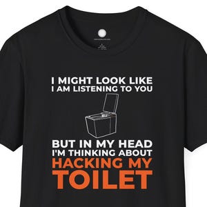Könnte beinhalten: Schwarzes T-Shirt mit dem Text "I MIGHT LOOK LIKE I AM LISTENING TO YOU BUT IN MY HEAD I'M THINKING ABOUT HACKING MY TOILET" in Weiß und Orange. Das Shirt zeigt eine Grafik einer Toilette.