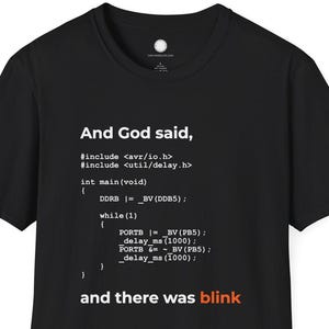 Könnte beinhalten: Schwarzes T-Shirt mit weißem Text: "And God said, ... and there was blink." Der Text sieht aus wie Computercode. Das T-Shirt hat einen Rundhalsausschnitt.