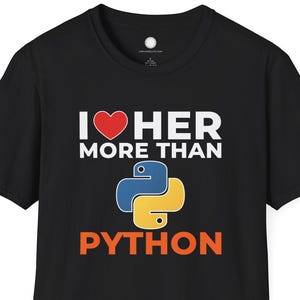 Op de afbeelding: Zwart T-shirt met de tekst "I ❤️ HER MORE THAN PYTHON". Het ontwerp bevat een rood hart en het logo van de programmeertaal Python in blauw en geel. Een casual T-shirt voor programmeurs.