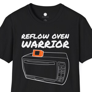 May include: Black t-shirt with the words "REFLOW OVEN WARRIOR" above a white outline drawing of a reflow oven. The oven has an orange square on top. A fun, graphic tee for electronics enthusiasts.