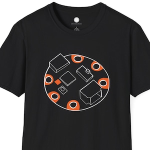 May include: Black t-shirt featuring a circular graphic with geometric shapes and orange accents. The design includes white outlined squares, rectangles, and circles. A simple, modern design for casual wear.