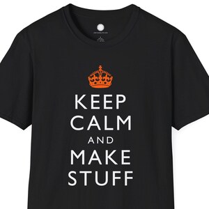 May include: Black t-shirt with the text "KEEP CALM AND MAKE STUFF" in white, topped with an orange crown graphic. The shirt is a classic crew neck style.