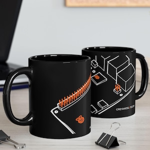 May include: Two black ceramic mugs with white and orange circuit board designs. One mug features a long row of orange pins, while the other displays a geometric layout. The text "GREYANDSLITE.COM" is visible on one mug.
