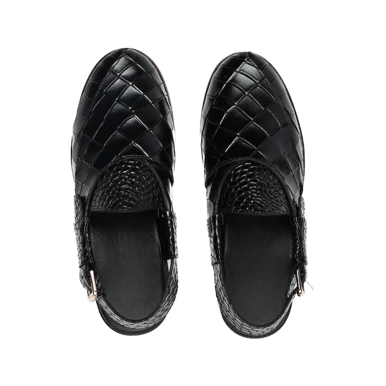 May include: A pair of black slip-on shoes featuring a woven leather-like upper with a glossy finish. The front section displays a grid-like pattern, while the tongue area has a textured, reptilian-inspired embossed design and a side buckle strap.