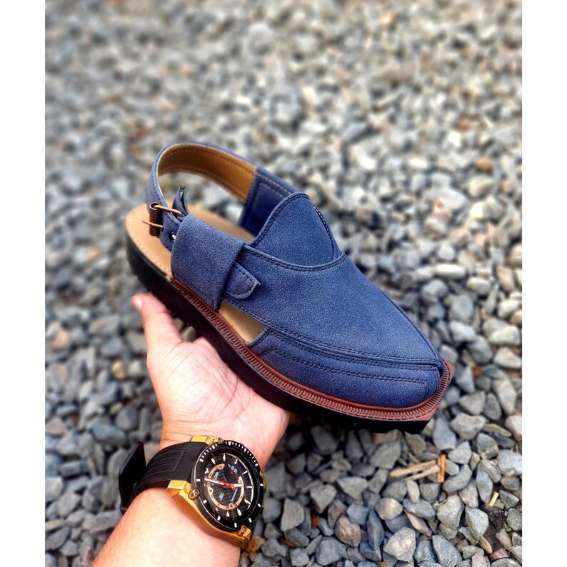 May include: Blue leather sandals with a buckle strap and a pointed toe. The sandals have a brown sole and are made of a soft, comfortable material.